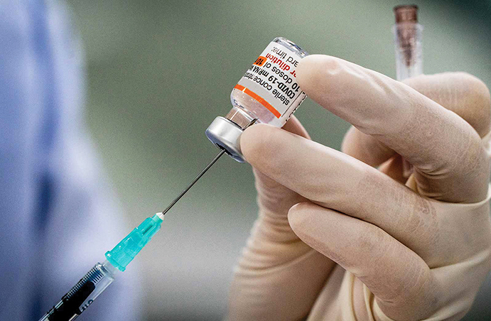 Close-up of nurse's hands preparing a Covid injection.