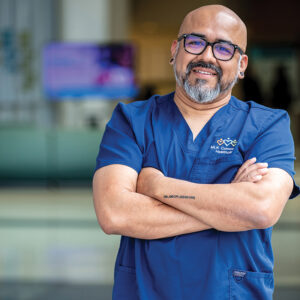 Male nurse wearing scrubs smiling