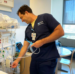 Male nurse wearing scrubs smiling