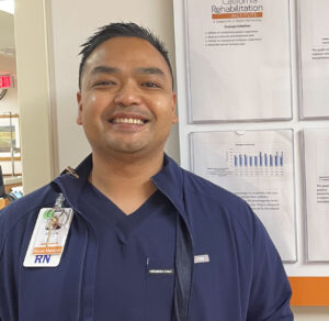 Male nurse wearing scrubs smiling