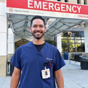 Male nurse wearing scrubs smiling