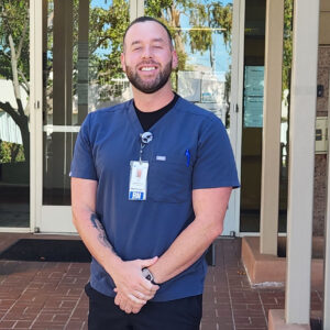 Male nurse wearing scrubs smiling