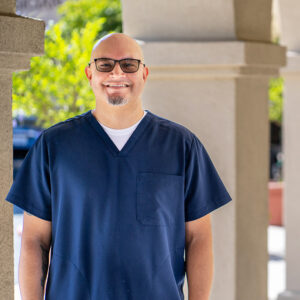 Male nurse wearing scrubs smiling