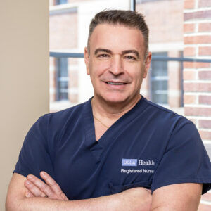 Male nurse wearing scrubs smiling